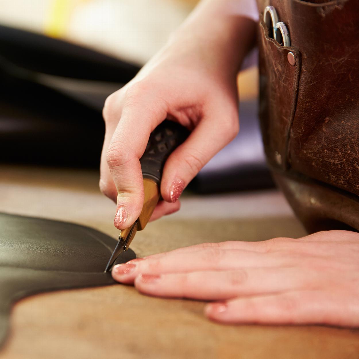 Woman hand tooling a piece of leather